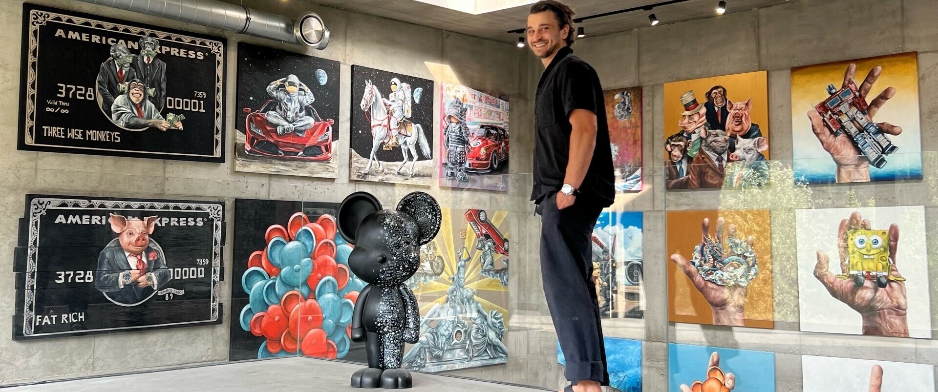 Marcin Rogal in his studio with paintings behind him